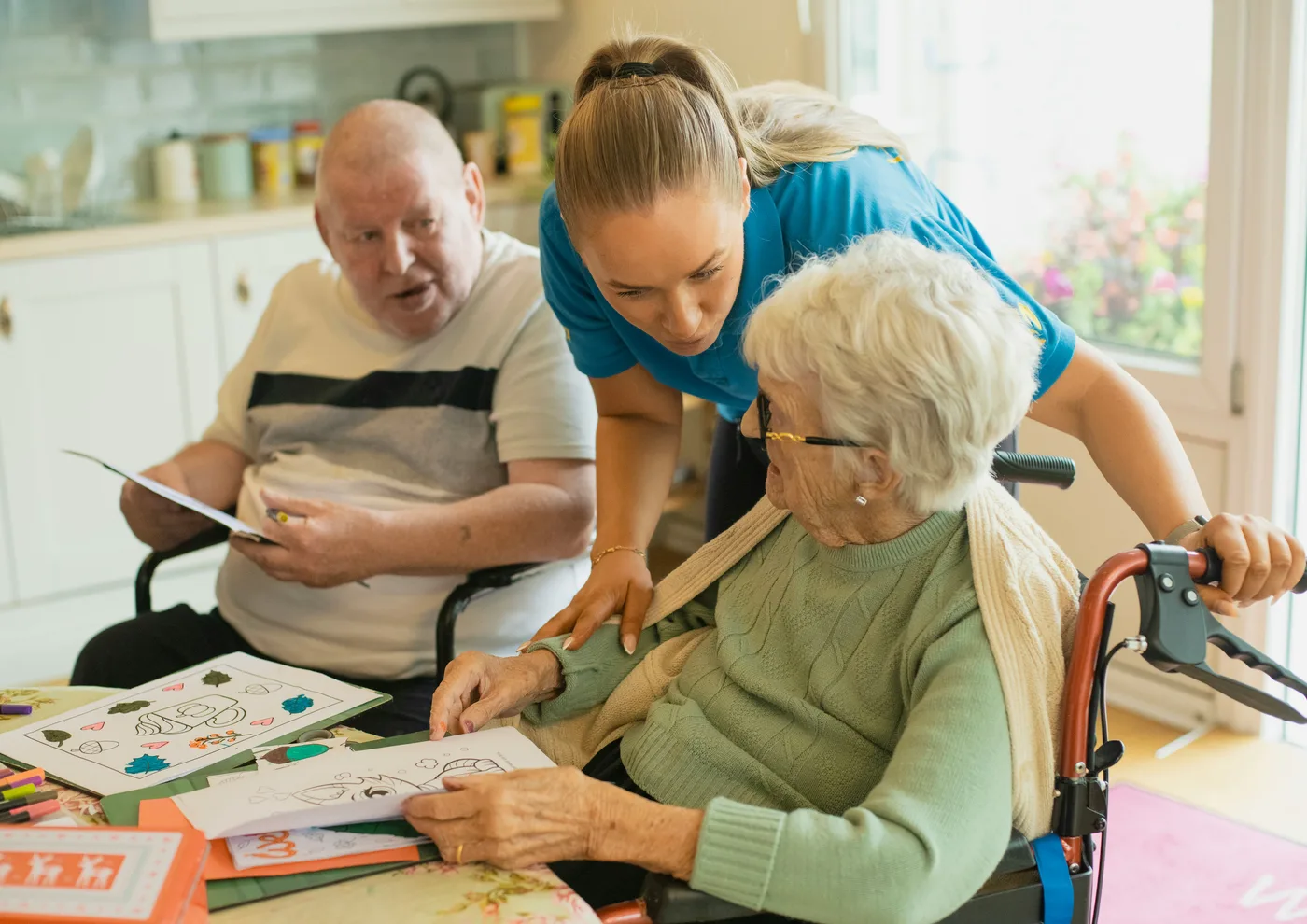 Soignante accompagnant deux aînés à la table, aide à domicile pour personnes âgées